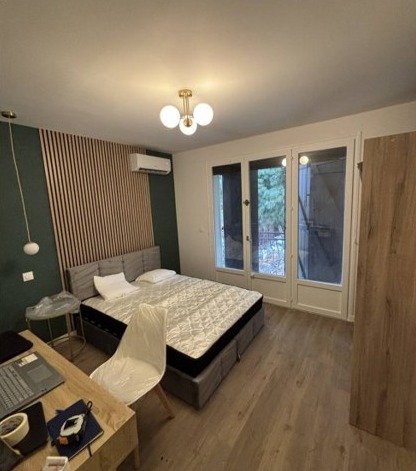 Chambre étudiante aménagée avec bois et mur vert